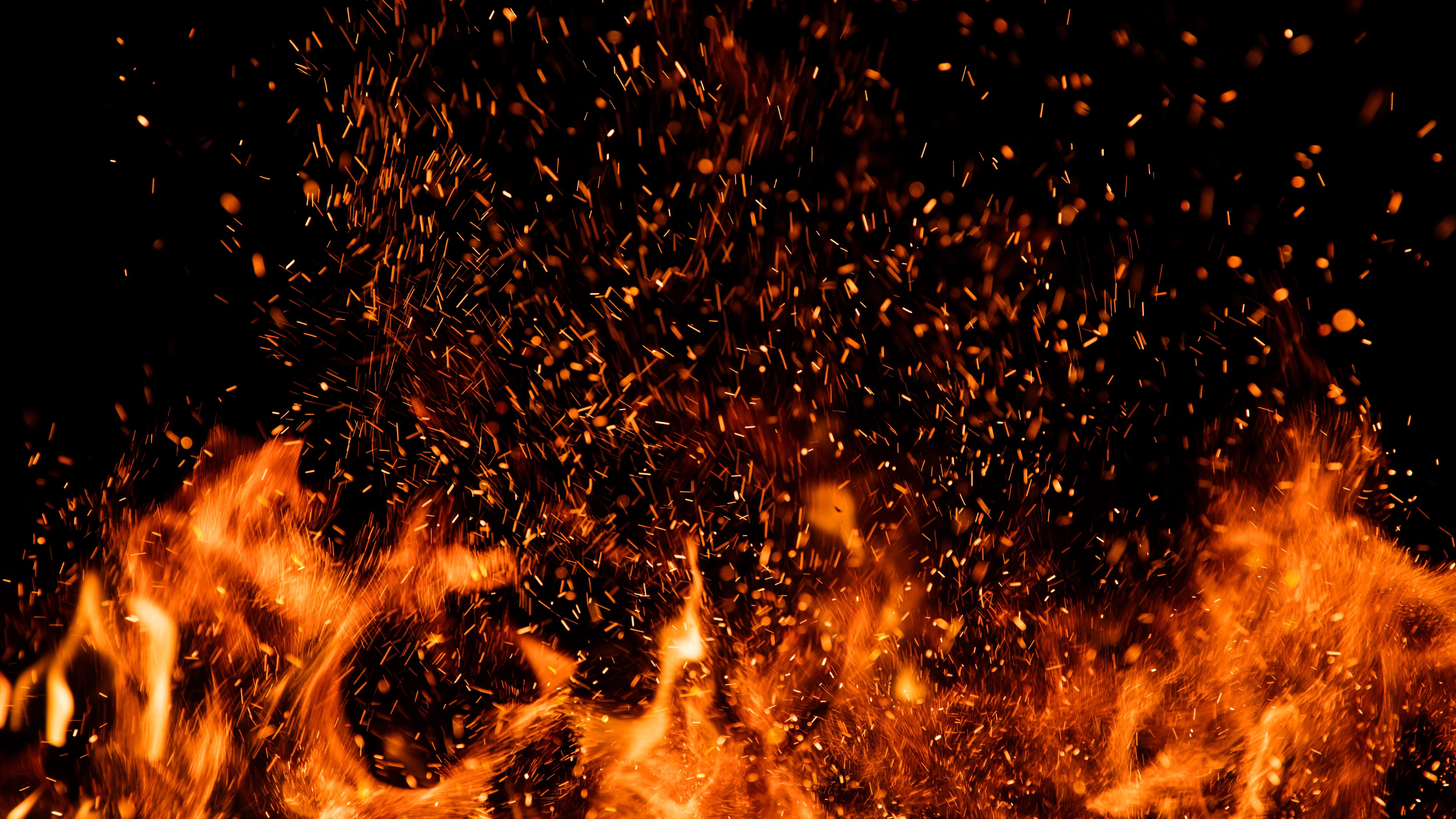 Detail of fire sparks isolated on black background. Abstract flaming background