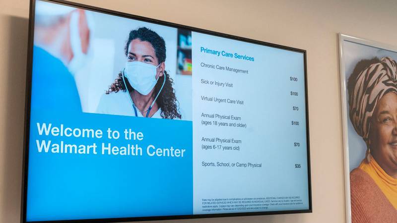 Television monitor displaying the costs of health care at a Walmart Health Center.